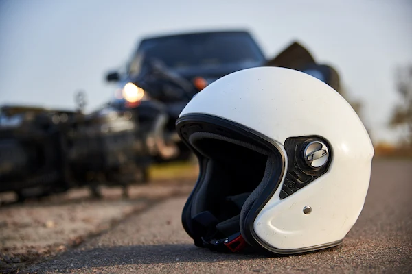 A helmet on the road after a motorcycle accident represents bias against motorcycle riders.